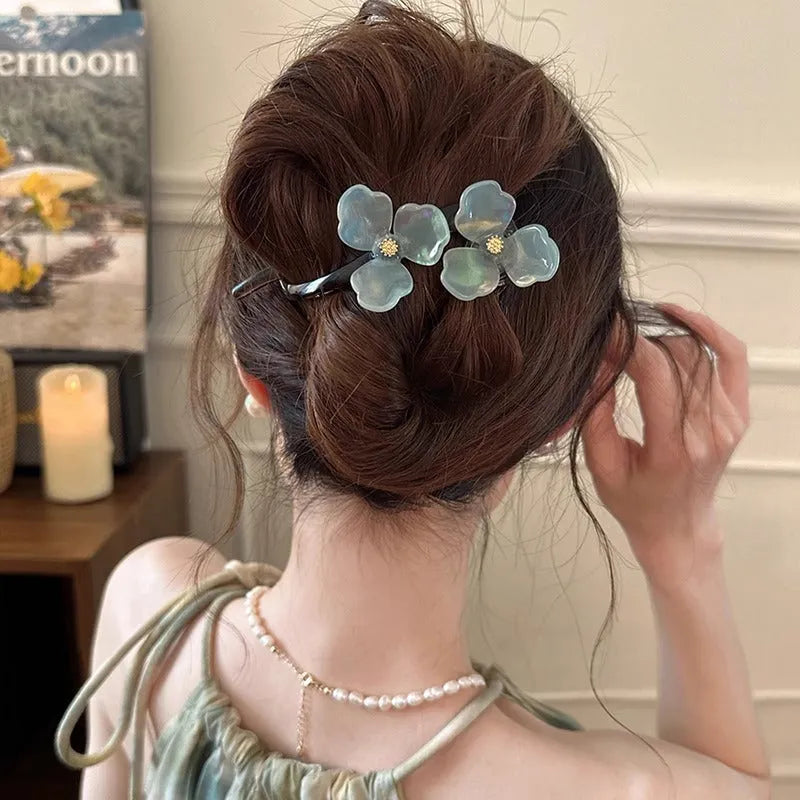 Close-up of a retro-style floral bobby pin with coloured acrylic petals.