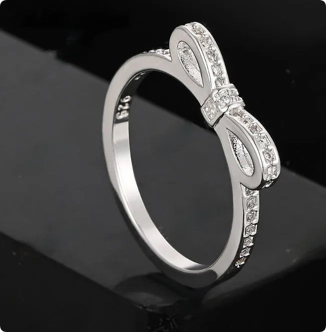 Silver bow-shaped ring with zircon rhinestone crystals on electroplated band
