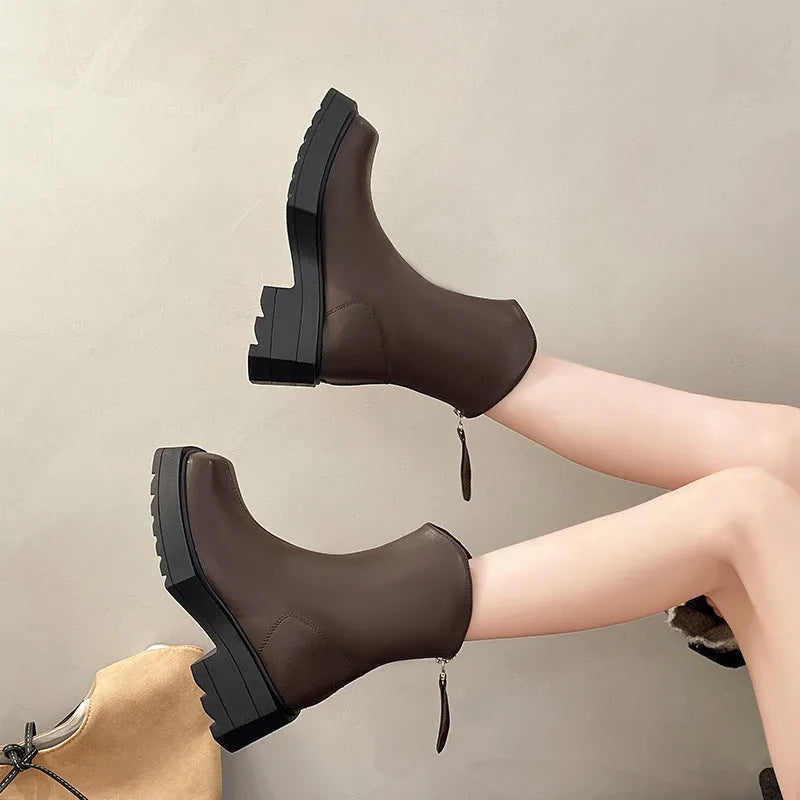 Women's black platform Martin ankle boots with a square toe and back zipper on a model.