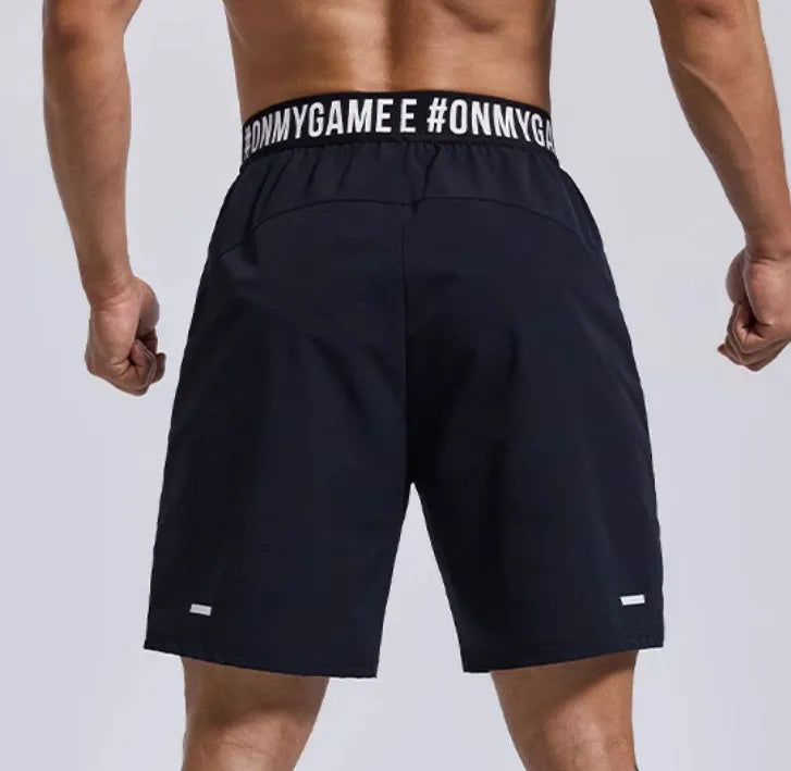 Men's black breathable sports shorts with letter detail and elastic waist.