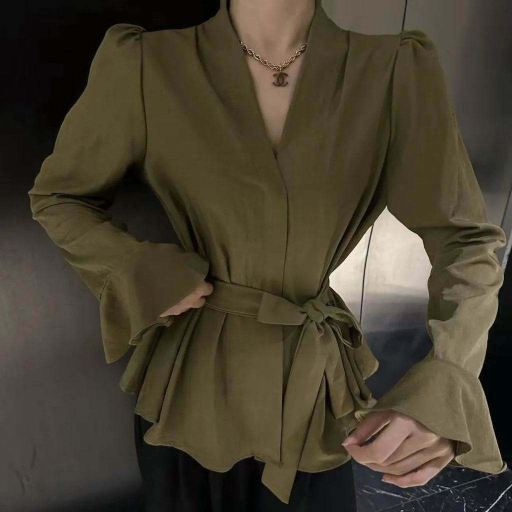 Women's black shirt with an irregular collar and long bell sleeves on a model.