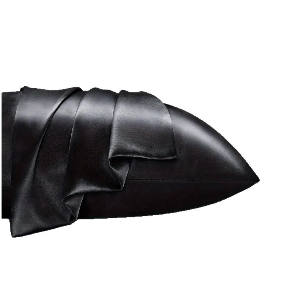 A pair of solid colour satin pillowcases in various colours and sizes on a bed.