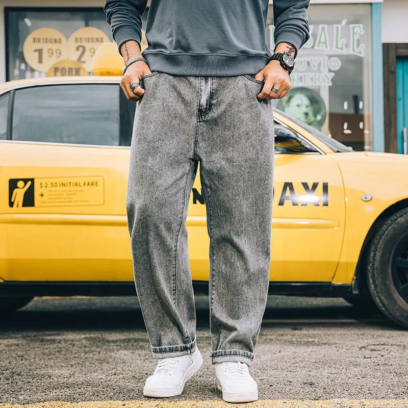 Man wearing dark blue loose straight-leg casual jeans with a mid-waist and zipper fly.
