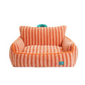 Striped orange plush dog bed with a removable cover on a wooden floor.