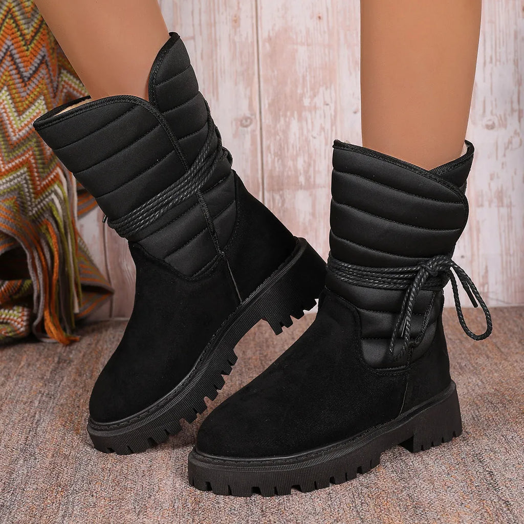 Women's black suede snow boots with chunky heel, fleece lining, and lace-up design.