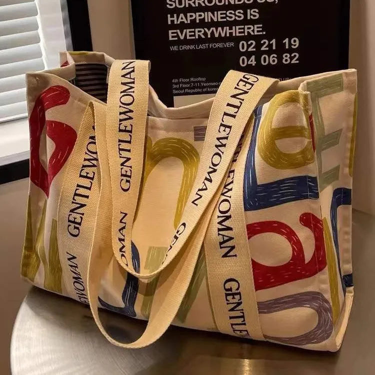 Canvas tote bag with printed design, available in black letters, coloured letters, and pattern style options.