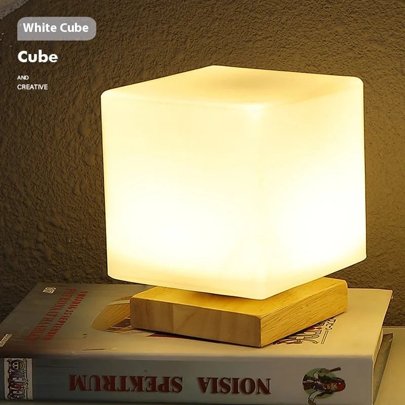 White Nordic solid wood USB table lamp with touch dimming in cube shape on a wooden table.