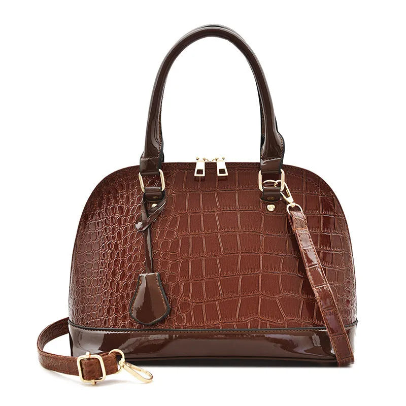 Large shiny black PU leather crossbody bag with shell suitcase shape on a model