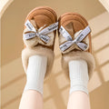 Women's beige suede half slippers with a black ribbon bow and thick white EVA sole