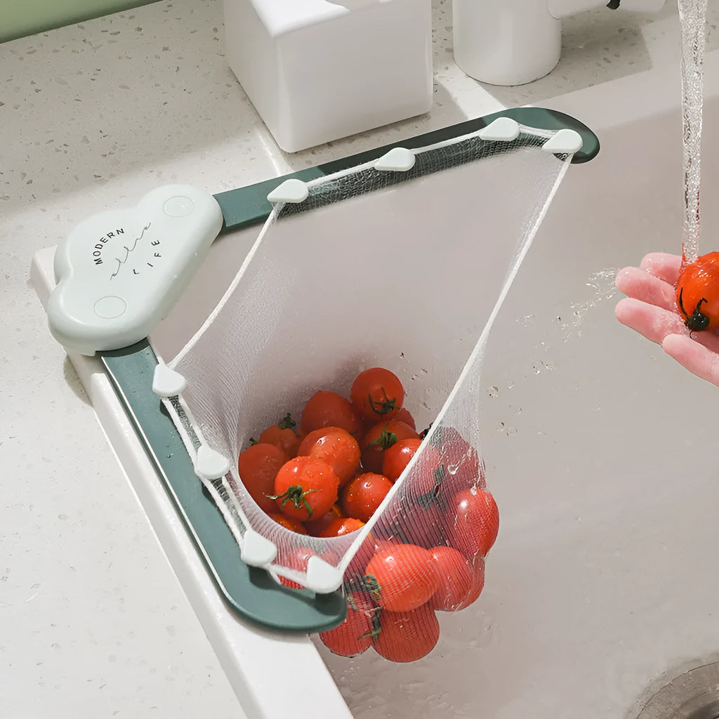 Triangular grey sink drain rack with filter mesh bag installed on a kitchen countertop.