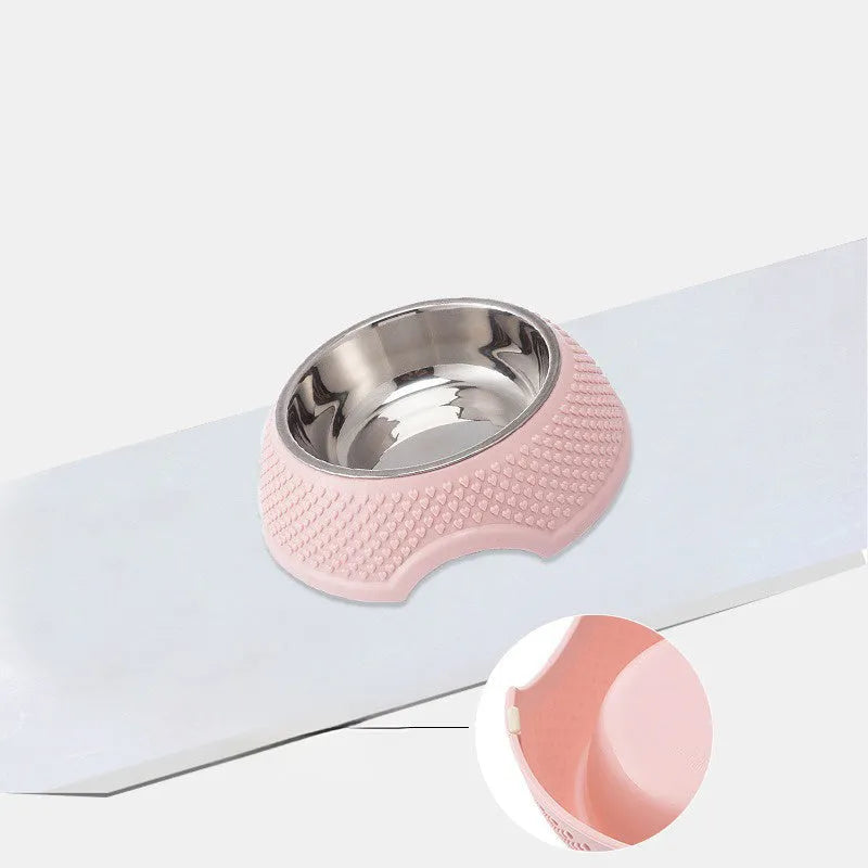 Set of four coloured stainless steel pet bowls with non-slip bases on a table.