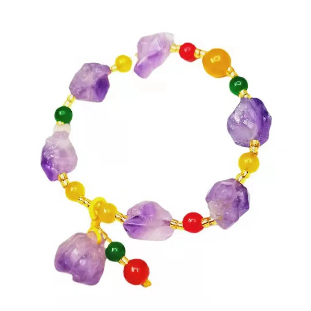 Purple amethyst bracelet with natural shaped beads and a fu character charm on a white background.