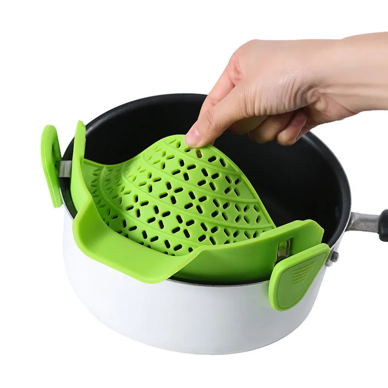 Green silicone pot side drain stopper kitchen gadget with stainless steel on wooden surface