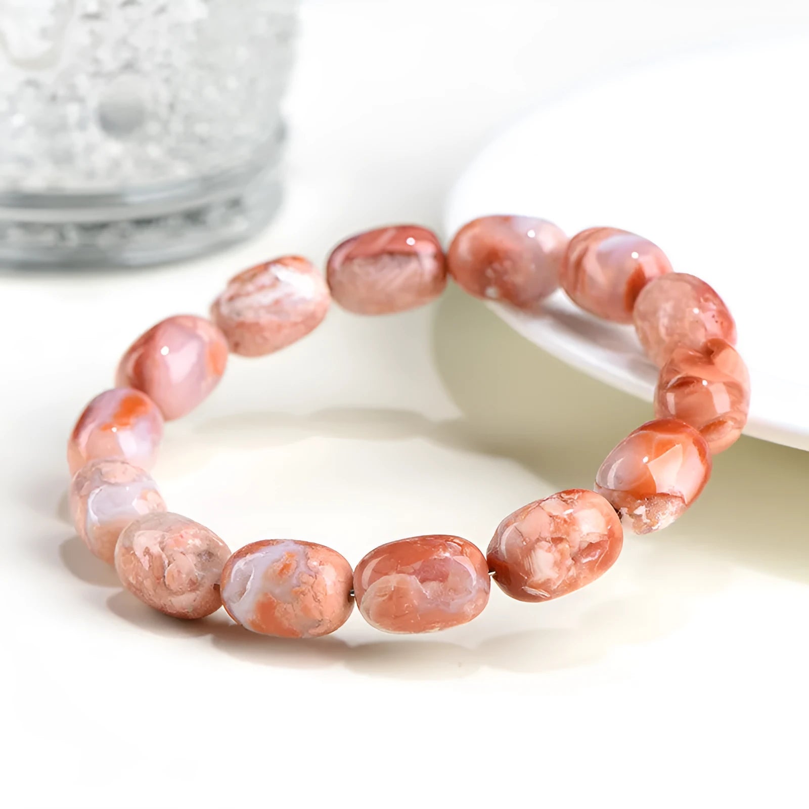 Natural cherry agate bracelet with barrel-shaped beads and a gold Ruyi charm on an adjustable strap.