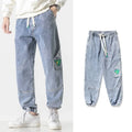 Men's loose-fit tapered cotton trousers in black, blue, and grey colours with mid waist design