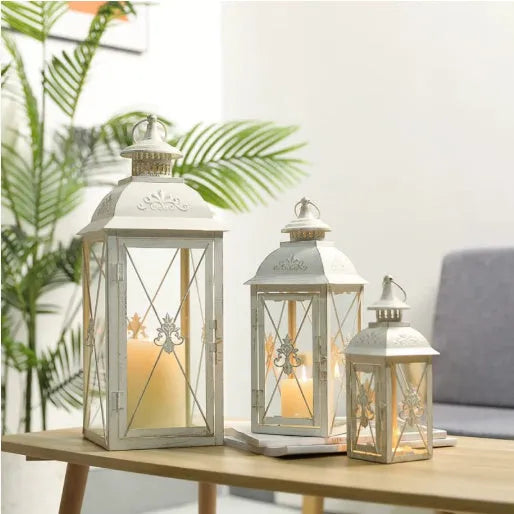 Black and white wrought iron floor storm lantern with tempered glass panels for courtyard decoration.