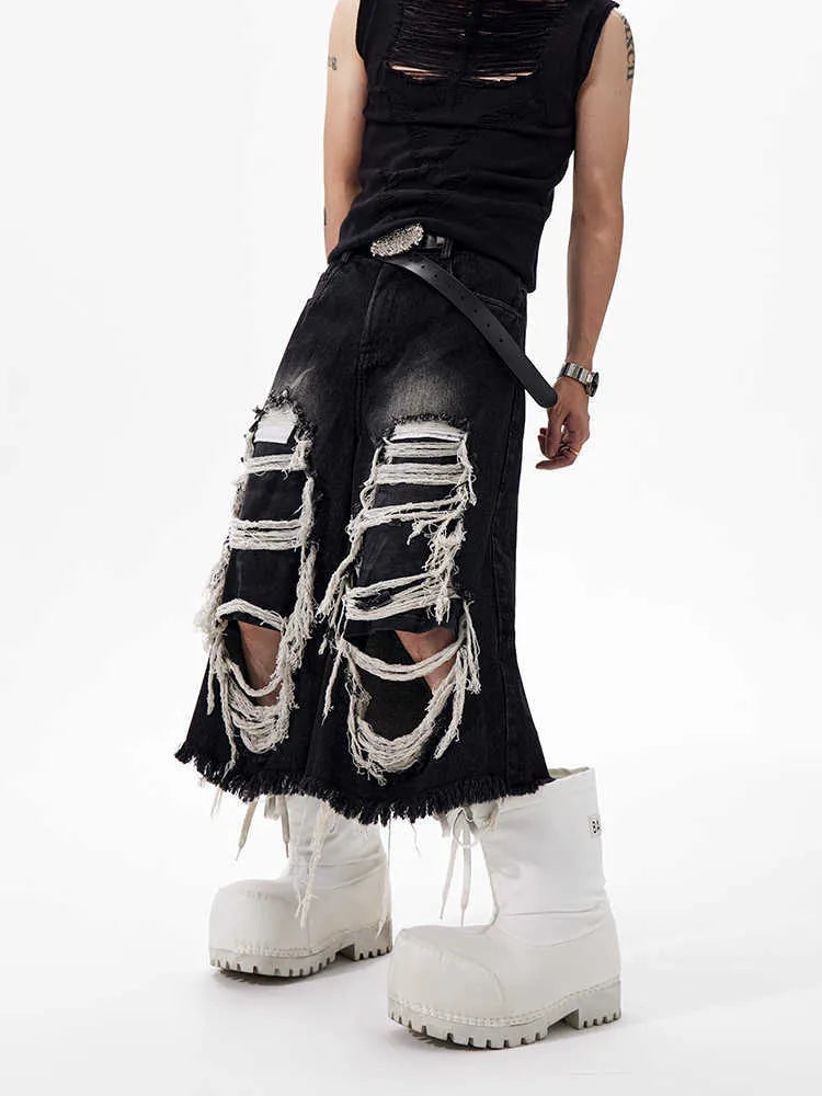 Model wearing black cropped wide-leg jeans with a distressed patch detail on the leg.