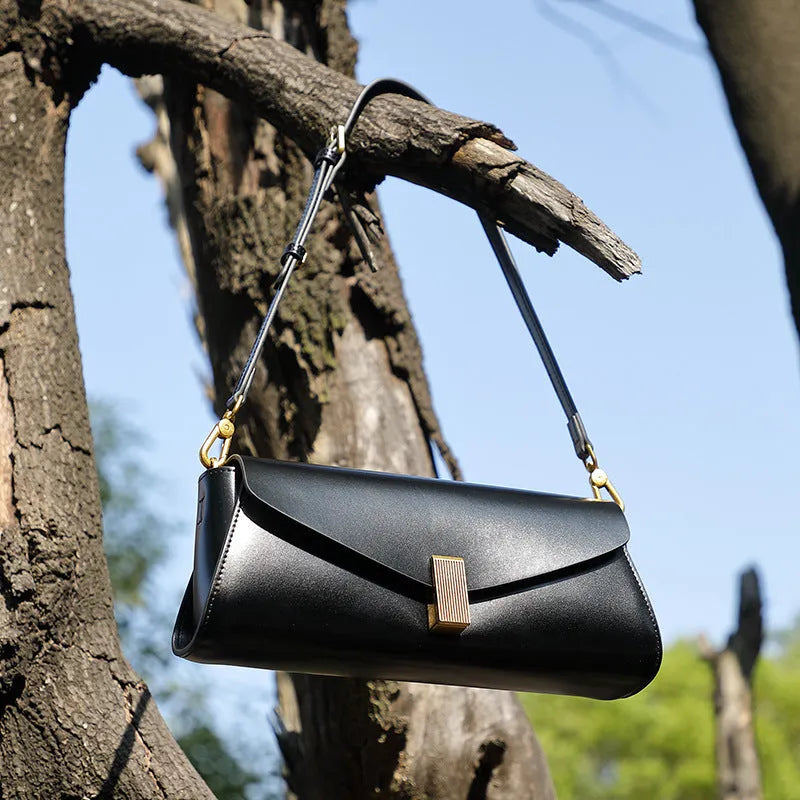 Cowhide leather women's cross-body bag in a clamshell, pillow-shaped design.
