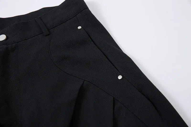 Man wearing black pleated wide-leg casual cotton trousers in a loose fit.