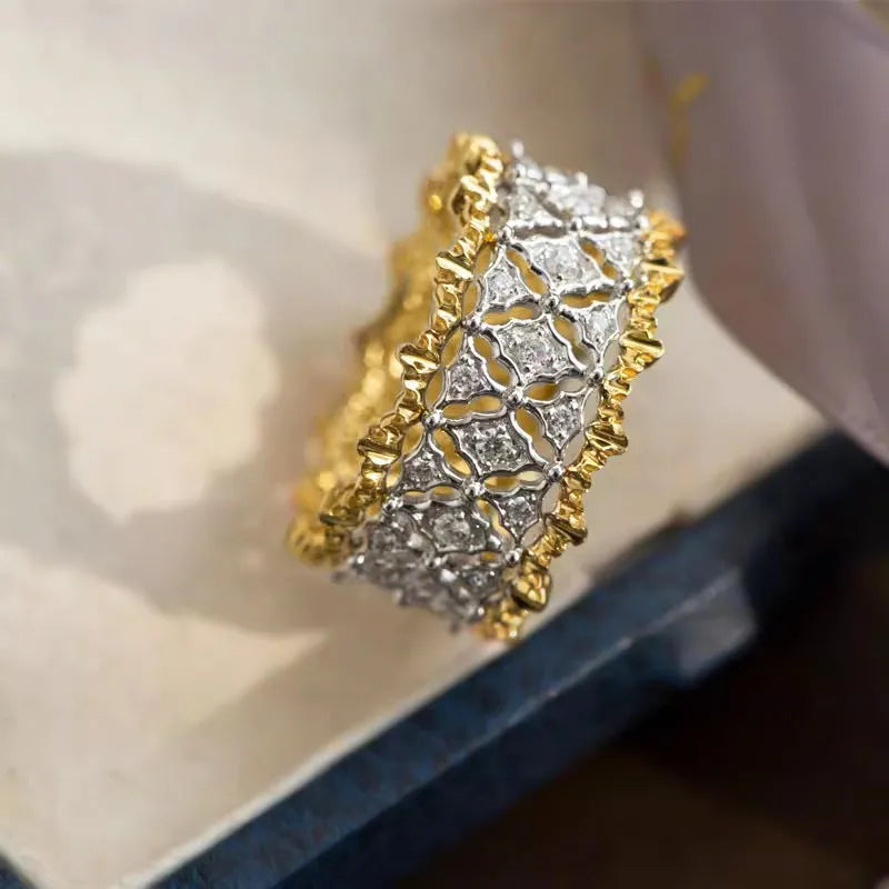 A geometric two-tone gold ring with a round zircon detail on a copper band.