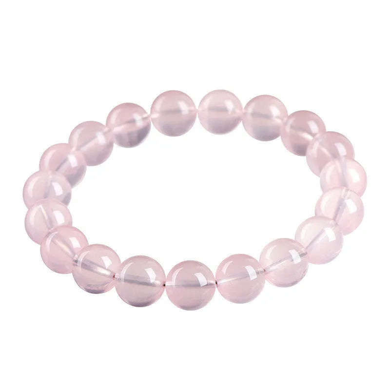 Women's pink polished crystal round bead bracelet in natural starlight style on a white background.