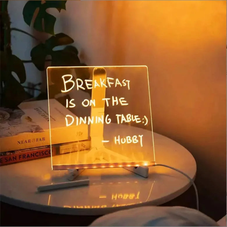 Acrylic LED message board night light on a desk with colourful handwritten notes glowing softly.