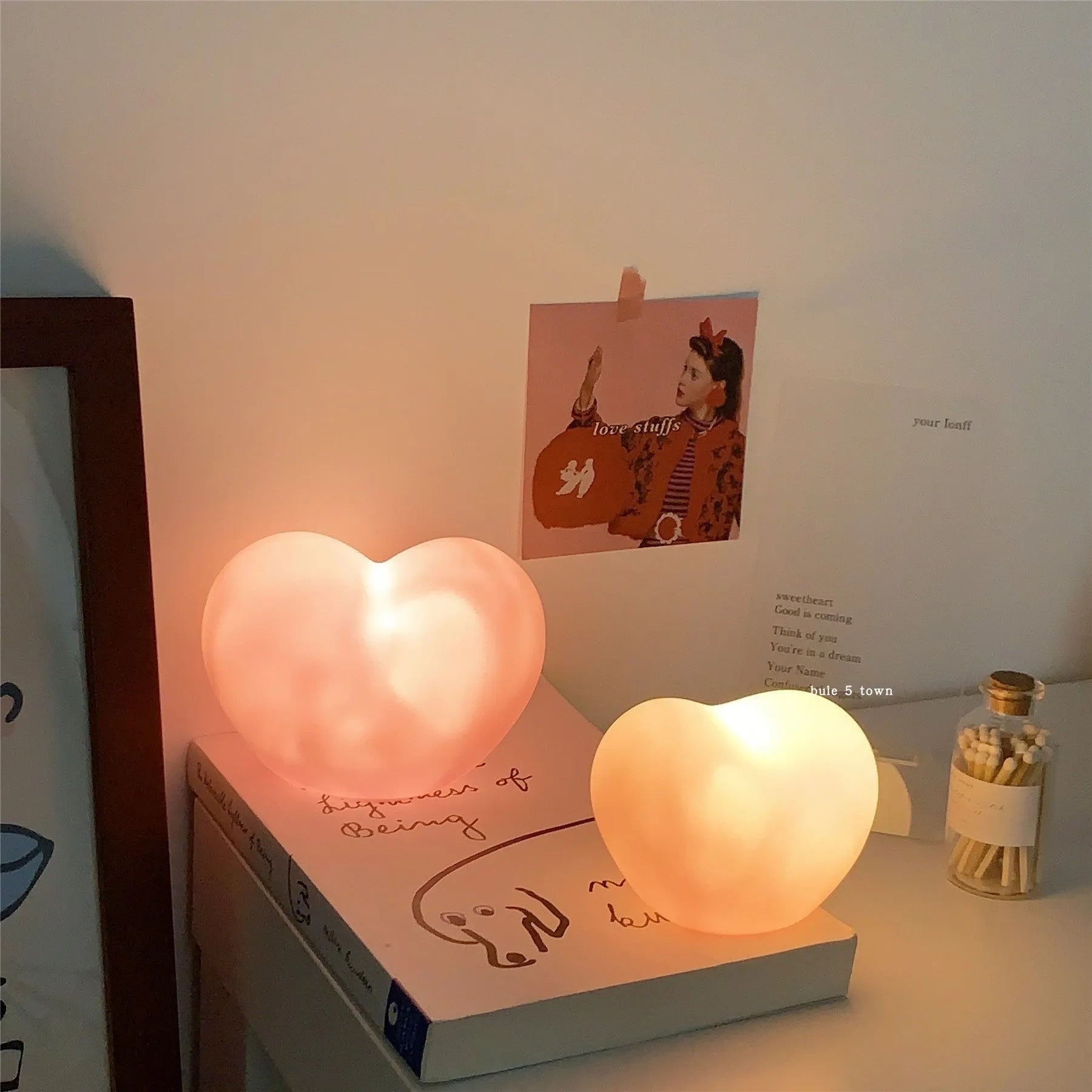 White or pink vinyl trumpet-shaped atmosphere lamp glowing warmly on a surface