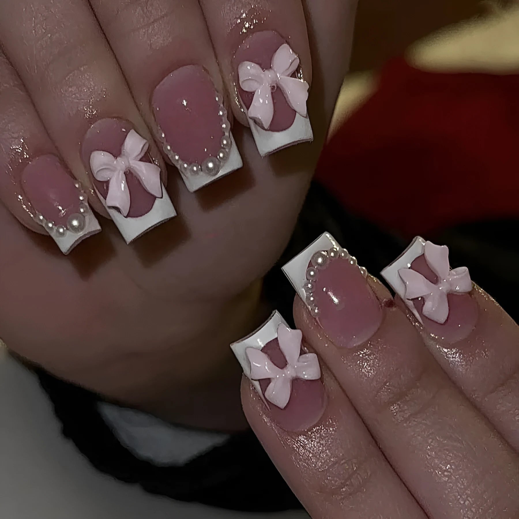 Short square French manicure artificial nails with white bow and floral patterns.