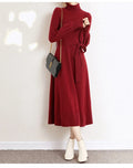 Rose red turtleneck knit dress with long sleeves, elastic waist, and a flared midi-length skirt.