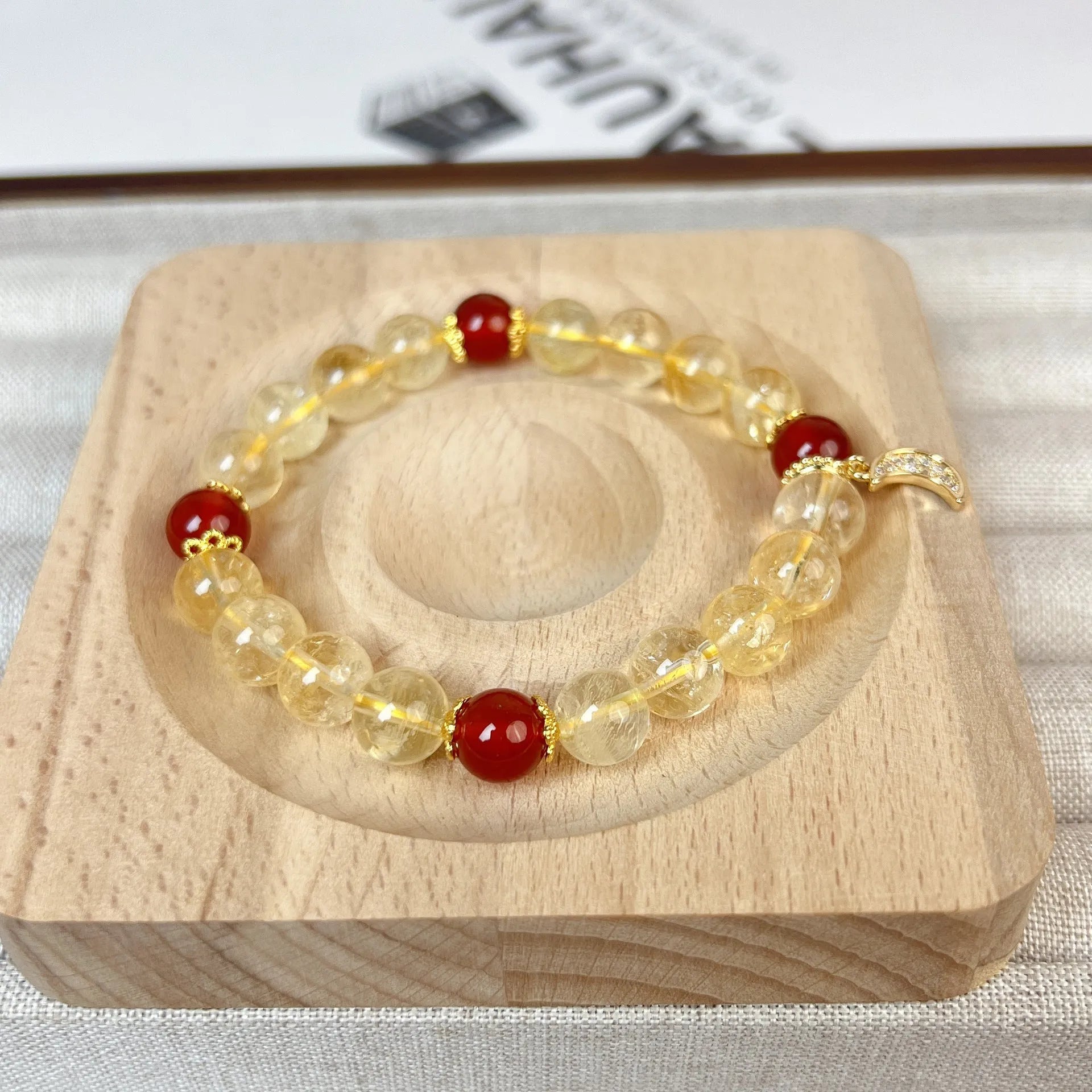 Women's handmade crystal bracelet featuring citrine and red agate beads in a moon boom style.