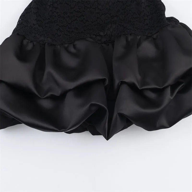 Women's black cotton short dress with lace stitching and asymmetric skirt on a plain background