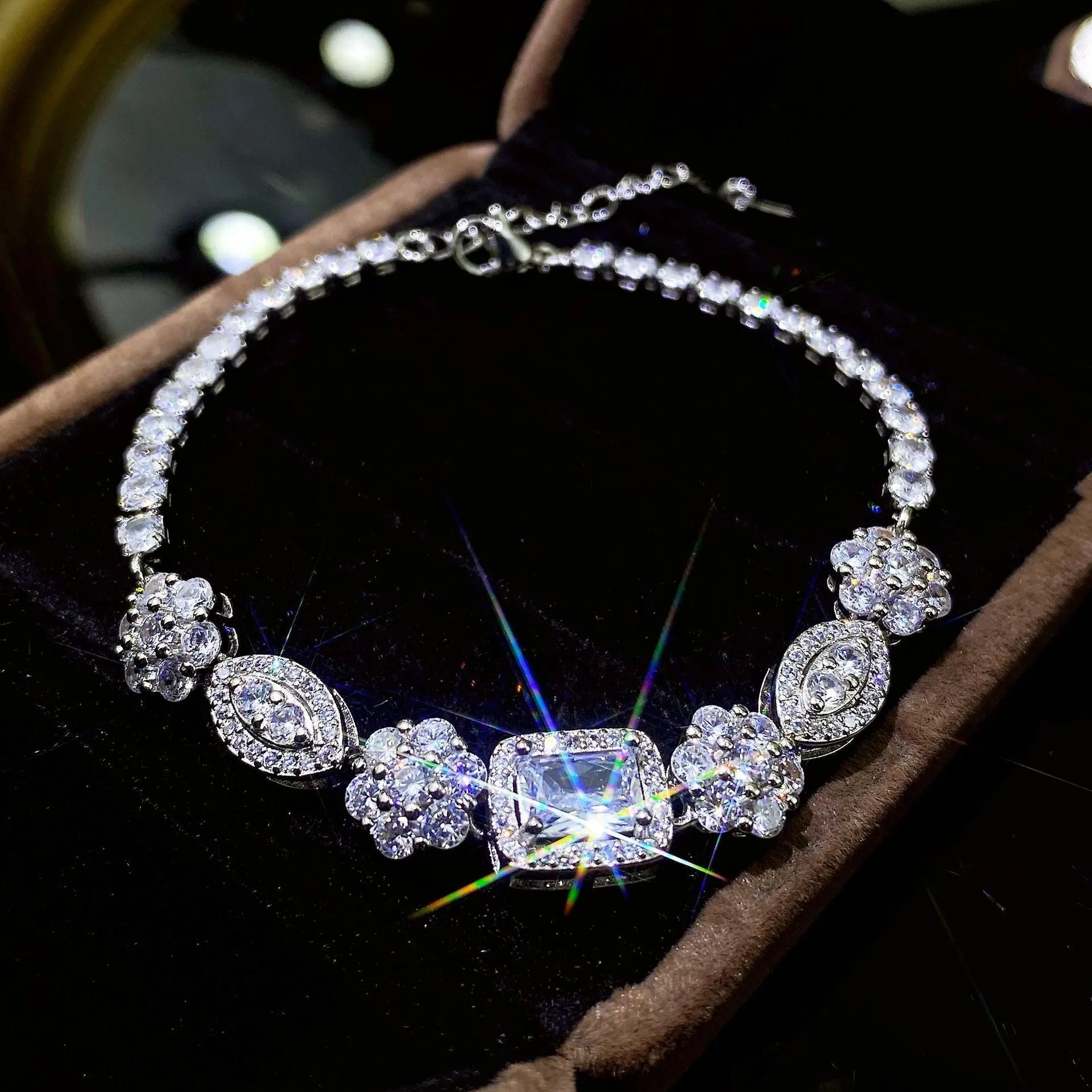 Women's geometric silver bracelet with zircon stones on a white background.