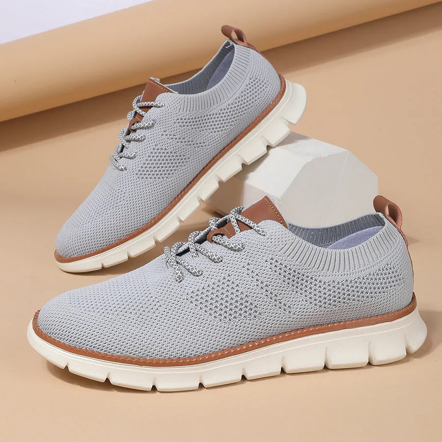 Men's grey and black low-top casual sneakers with woven mesh fabric upper and round toe.