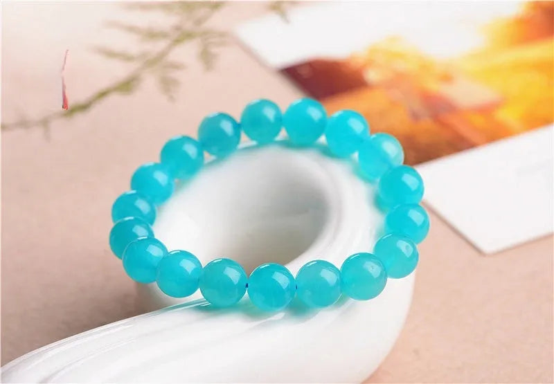 Selection of polished blue-green Amazonite scattered beads in different sizes for making a crystal bracelet.