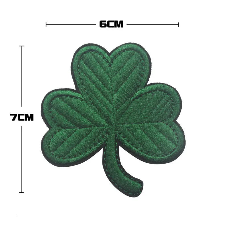 Embroidered fabric badge with Velcro strip backing on a green clover design