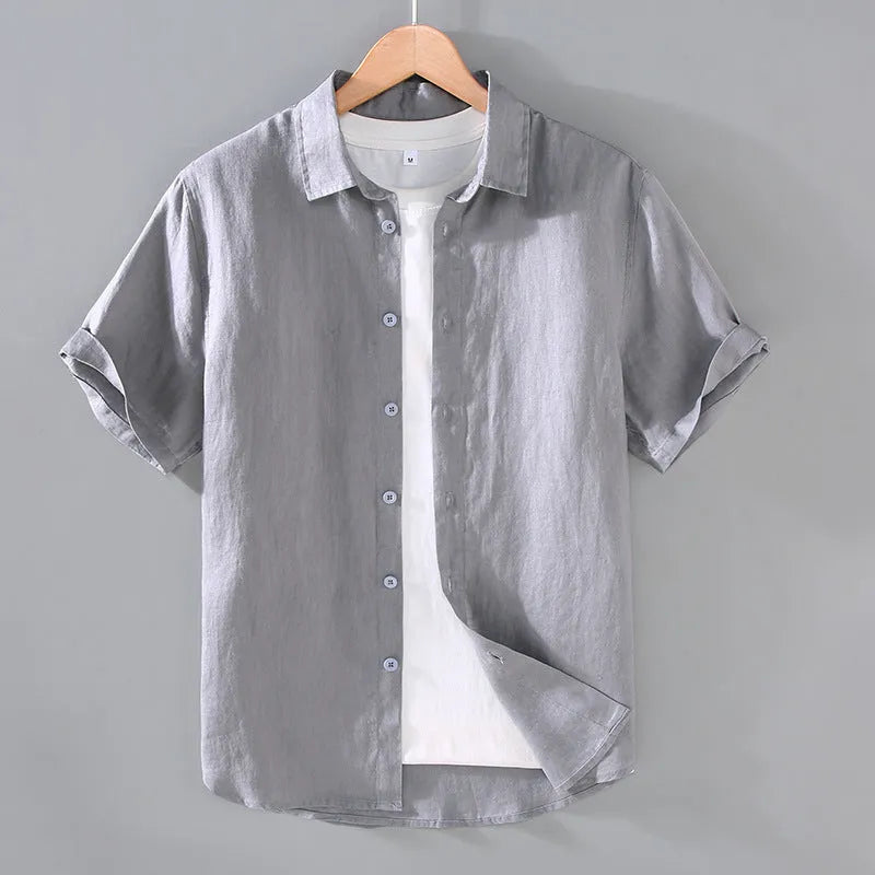 Man wearing a grey short-sleeved linen shirt in a casual cardigan style.