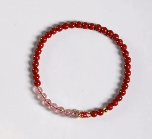 Hand-woven purple gold sand and strawberry quartz koi bracelet with crystal and pearl beads on a light background.