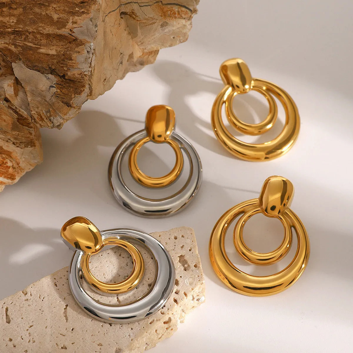 Round double-layer hollow stud earrings with 18K gold electroplated finish on titanium steel