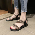 Women's flat silver sandals with round toe, rhinestone details, and an elastic strap.