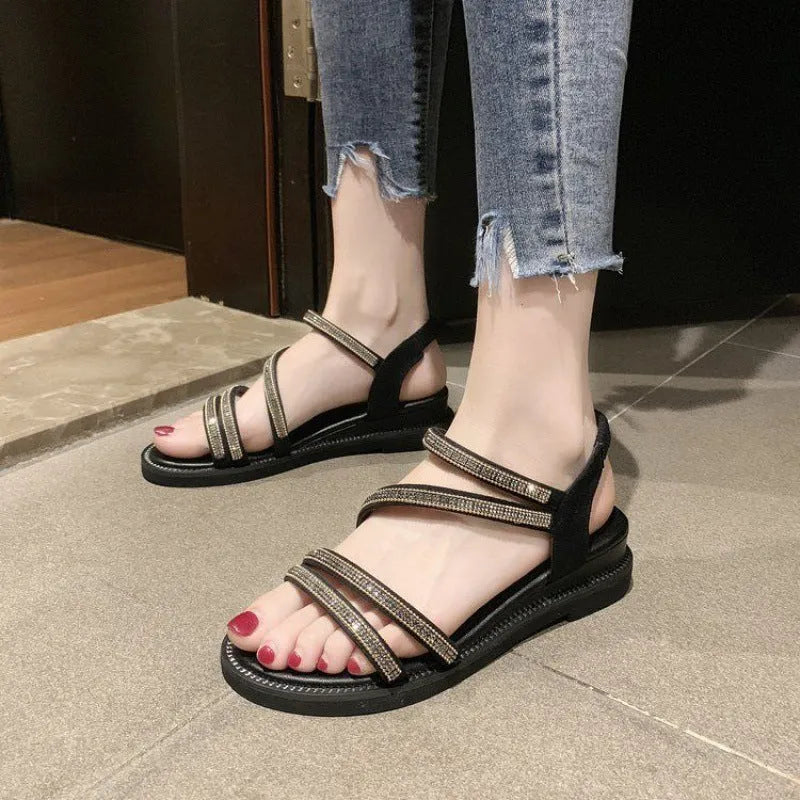 Women's flat silver sandals with round toe, rhinestone details, and an elastic strap.