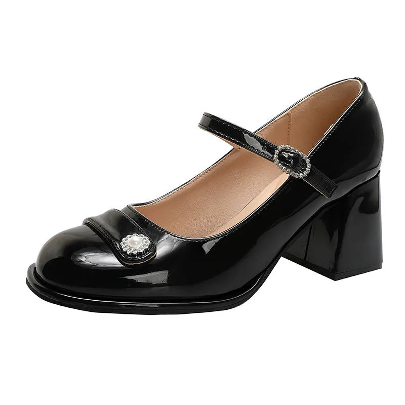 Women's black patent leather chunky heel court shoes with round toe and buckle fastening.