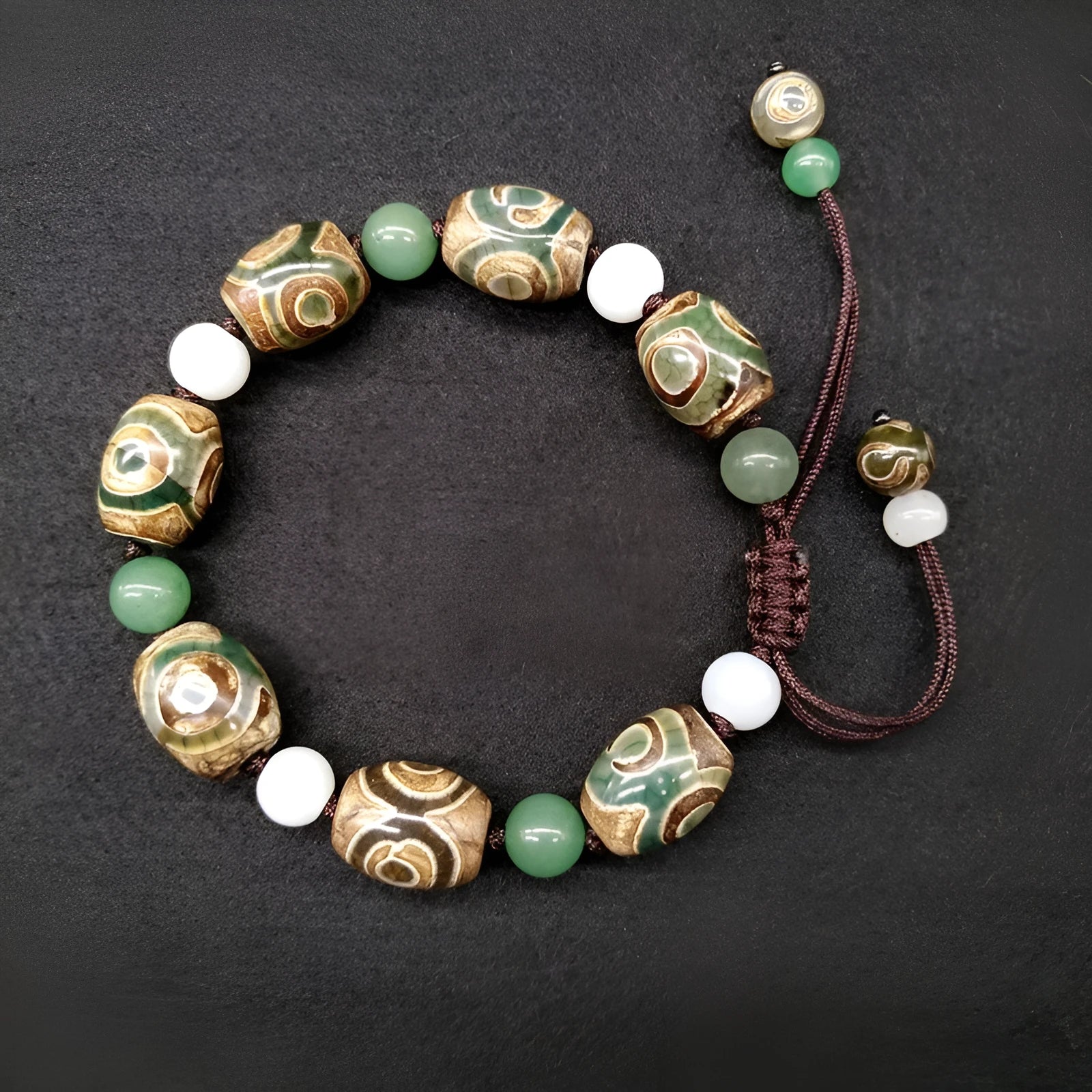 Green agate ethnic bracelet with a large three-eye bead and hand-woven band.