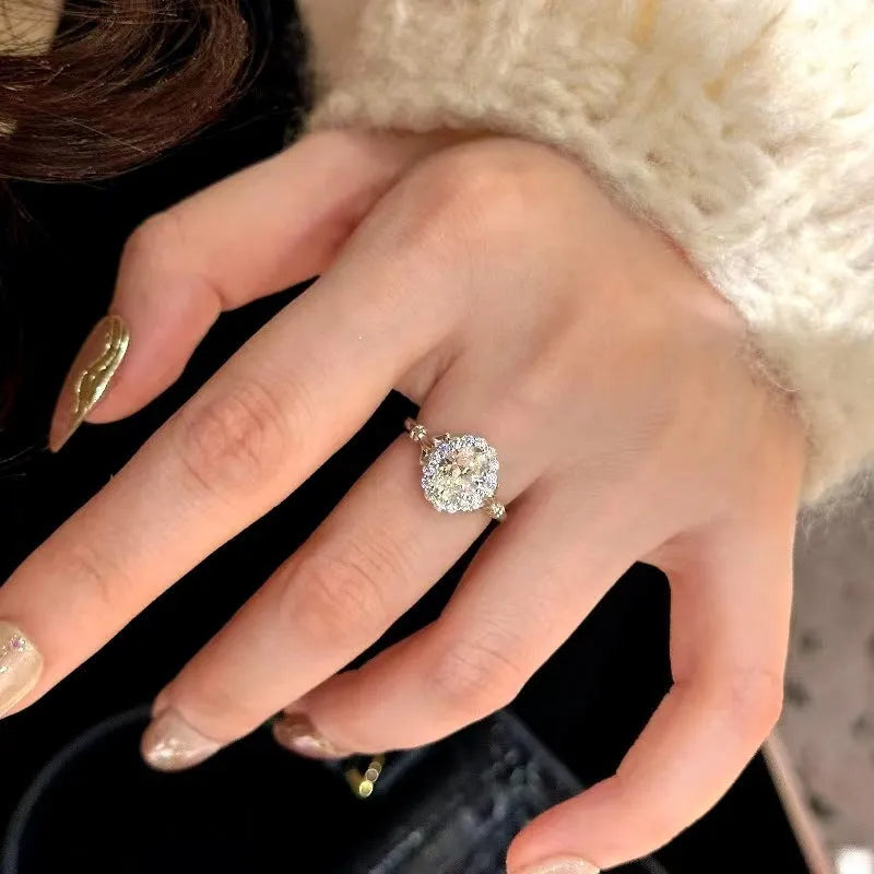 Silver-coloured geometric ring with ellipse detail and adjustable opening on a plain background.