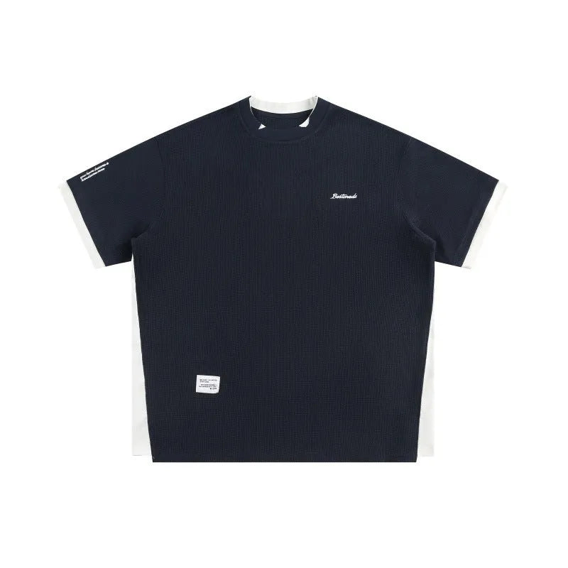 Retro alphabet embroidered loose waffle knit t-shirt in navy blue, shown on a hanger.