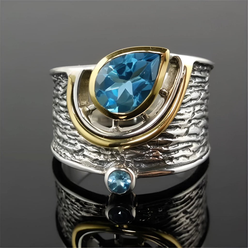 Blue zircon stone set in a drop-shaped alloy ring with Chinese style design.