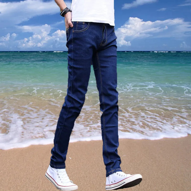 Thin men's loose skinny casual jeans in pure black with low waist, cropped leg, small leg opening, and zip fly.