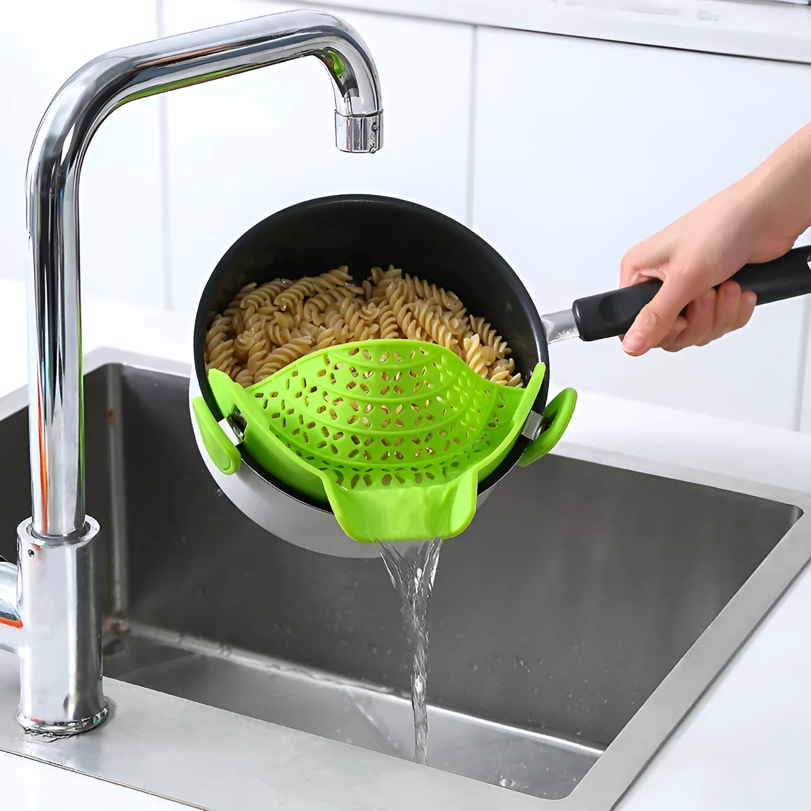 Green silicone pot side drain stopper kitchen gadget with stainless steel on wooden surface