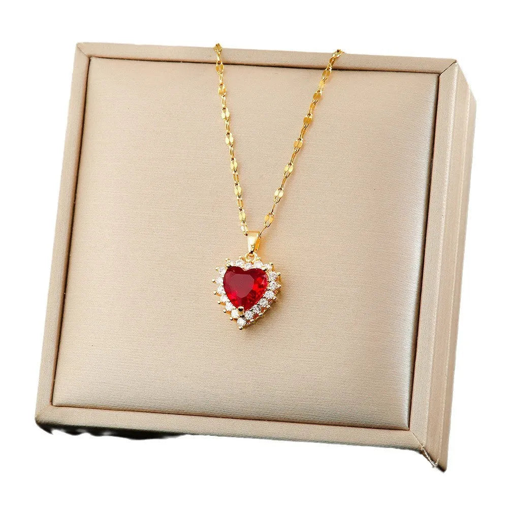 Gold red titanium steel jewellery set with heart and floral pendant, including necklace, ring, and ear studs.