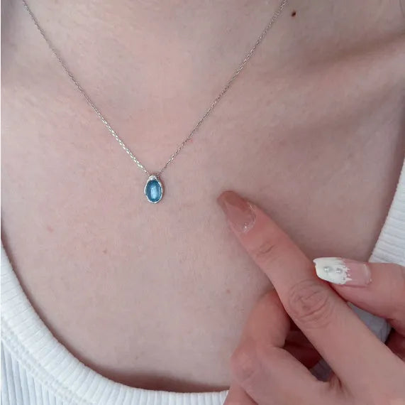 A women's navy blue geometric water drop pendant necklace with a platinum-colour finish on an adjustable cross chain.