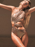 Gold coloured backless one-piece swimsuit for women on a hanger.